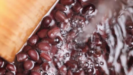 close-up view of water adding into cooked red beans