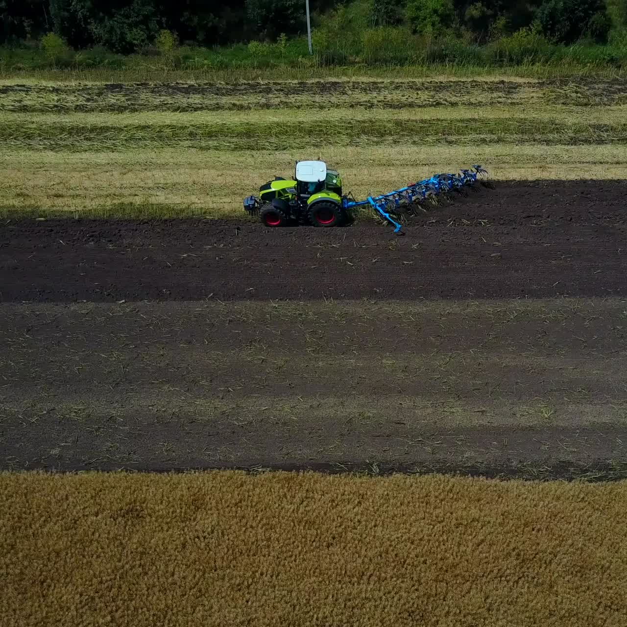 Plow Attached To A Tractor On A Field