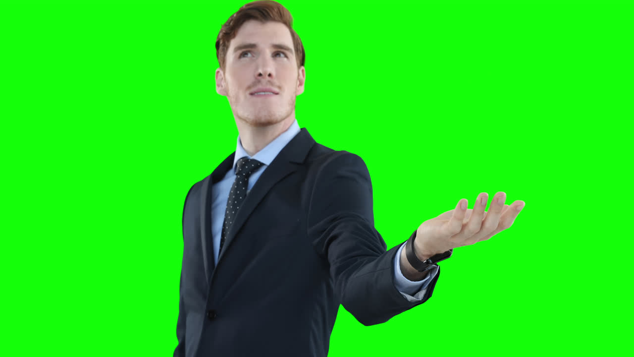 Uomo caucasico che guarda in alto e alza la mano su sfondo verde