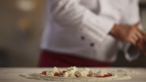 Pastry-cook-making-pizza-pepperoni-in-restaurant-kitchen.-Cooking-food-concept.