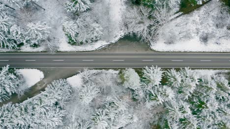 Seguimiento-Aéreo-De-Un-Camión-Rojo-Que-Conduce-A-Través-De-Una-Calle-Rural-Invernal,-Directamente-Desde-Arriba-Filmado-Por-Drones