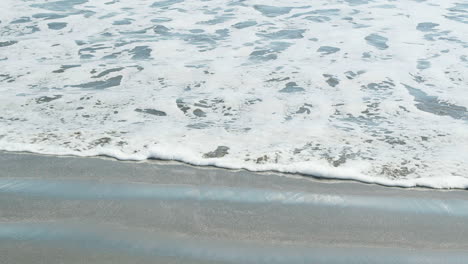 closeup of a wave as it rushes onto the beach in slow motion