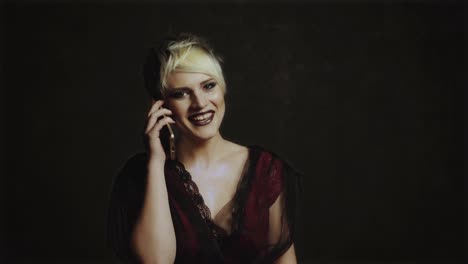 young beautiful woman with smart phone. pretty laughing woman talks on the phone standing on black background