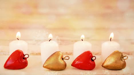 velas y decoración navideña combinadas con la nieve que cae