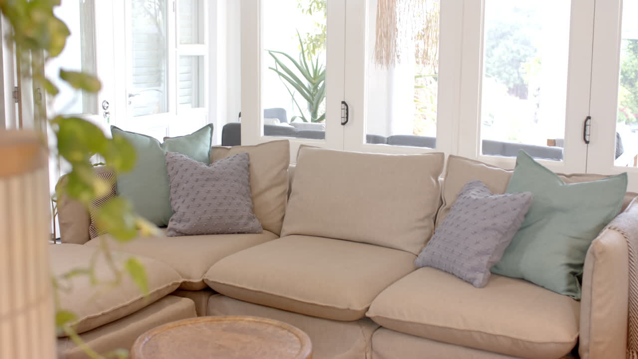 Cozy living room with beige sectional sofa and decorative pillows, inviting ambiance
