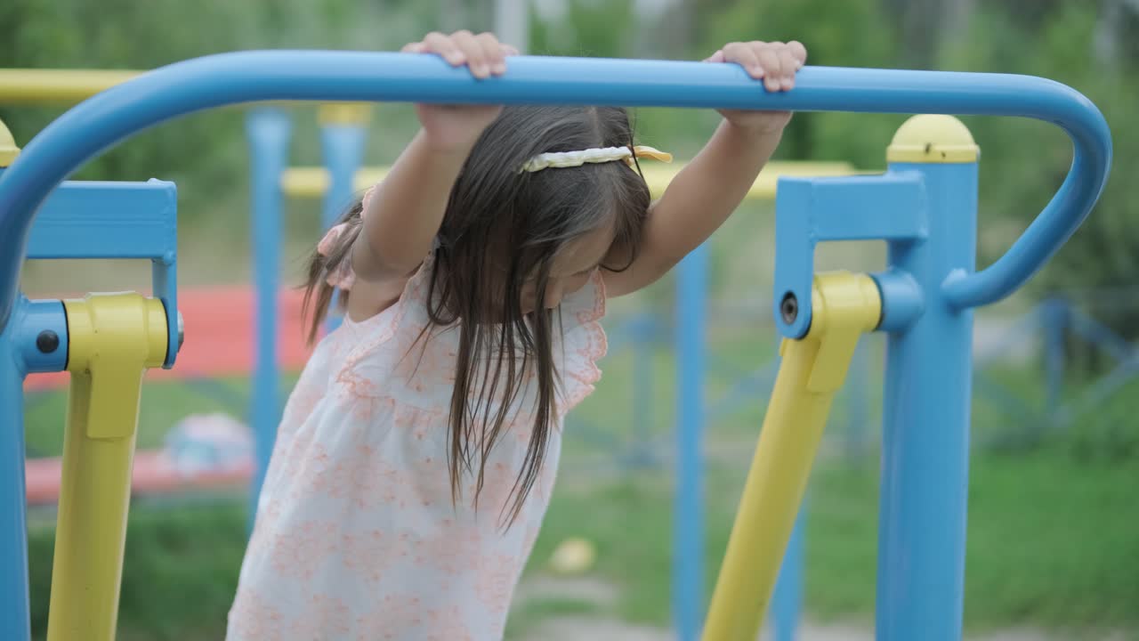 una madre embarazada y su hija joven disfrutan de un tiempo de juego juntos en un patio de recreo en el parque, rodeados de árboles y vegetación