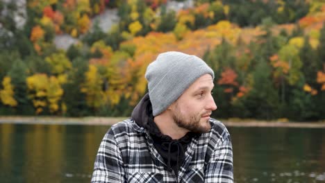 handsome man on gorgeous wild fall lake contemplates life, handheld