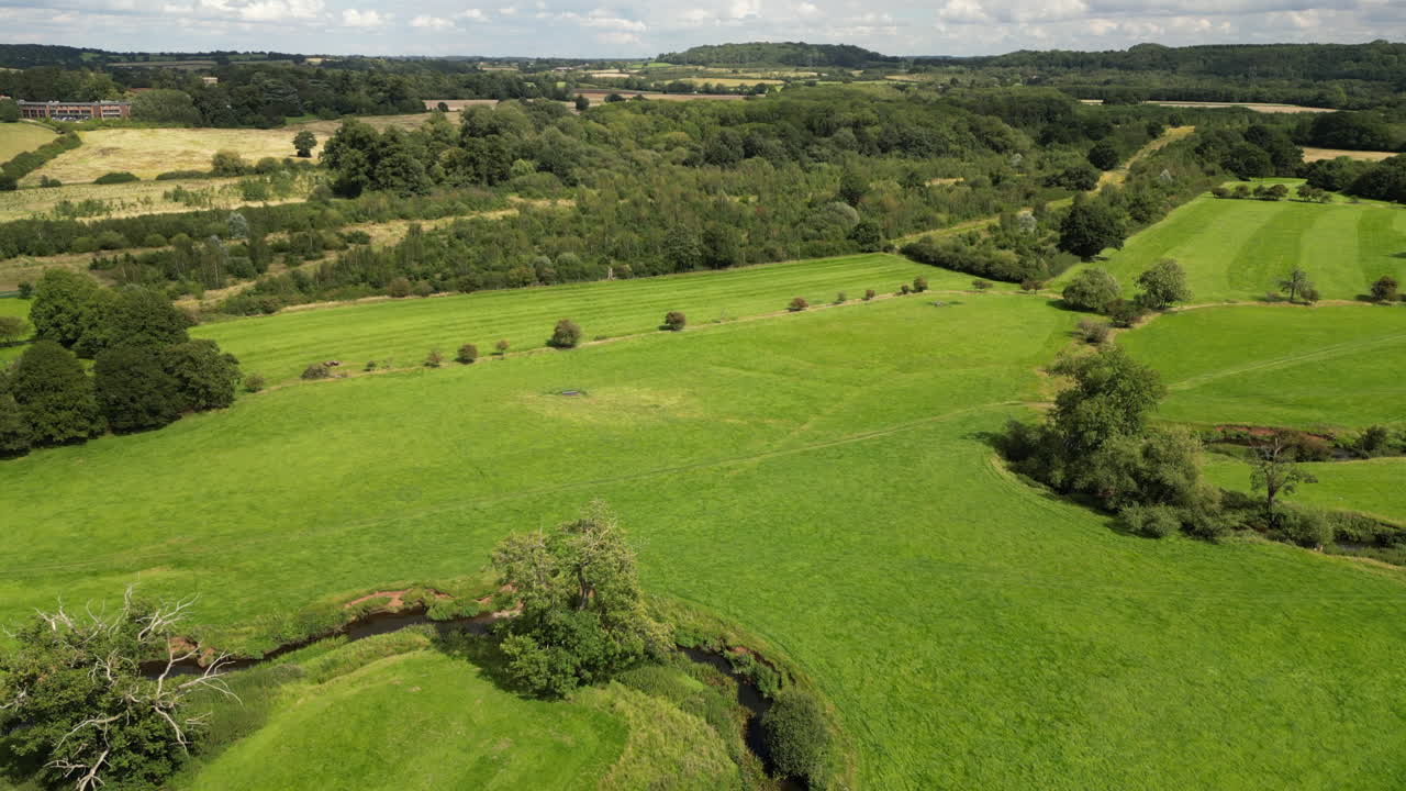 La rigogliosa campagna verde e il tortuoso fiume Arrow nel Warwickshire, Inghilterra, visti dall'alto.