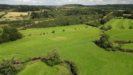 The-lush-green-countryside-and-the-winding-river-Arrow-in-Warwickshire,-England-as-seen-from-the-air