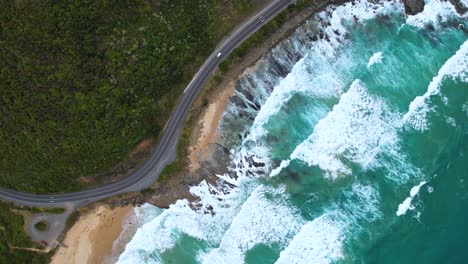 4k drone birds eye view of a camper van driving along the great ocean road in victoria, australia