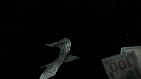 falling flying american canadian dollar banknotes on a black background in 4k loopable. high quality falling dollar banknotes in 4k. video is loopable