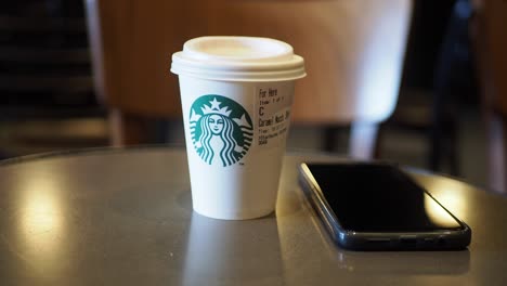 starbucks coffee and smartphone on table