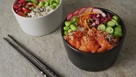 composition of bowls with rice, salmon and vegetables on white background