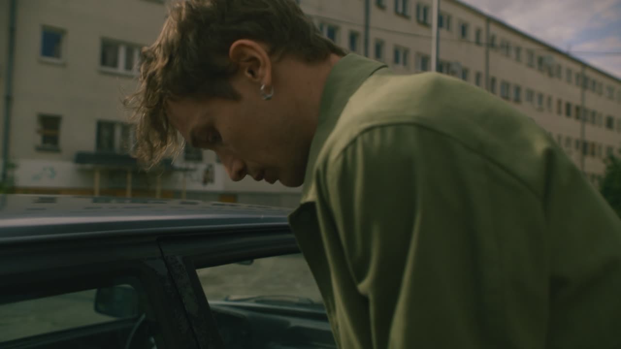 ⁇ 고  ⁇ 은 남자가  ⁇ 은 차를  ⁇ 쳐서 돈을 벌려고 시도하는 클로즈업 비디오 미국의 거친 동네에서 낮은 경찰 존재감