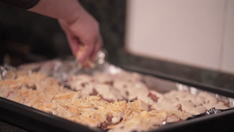 preparing a cheesy meat dish in the oven