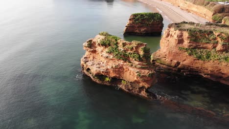 Aerial-stationary-shot-of-a-Red-Sandstone-Stack-of-the-coast-at-Ladram-Bay-Devon-England