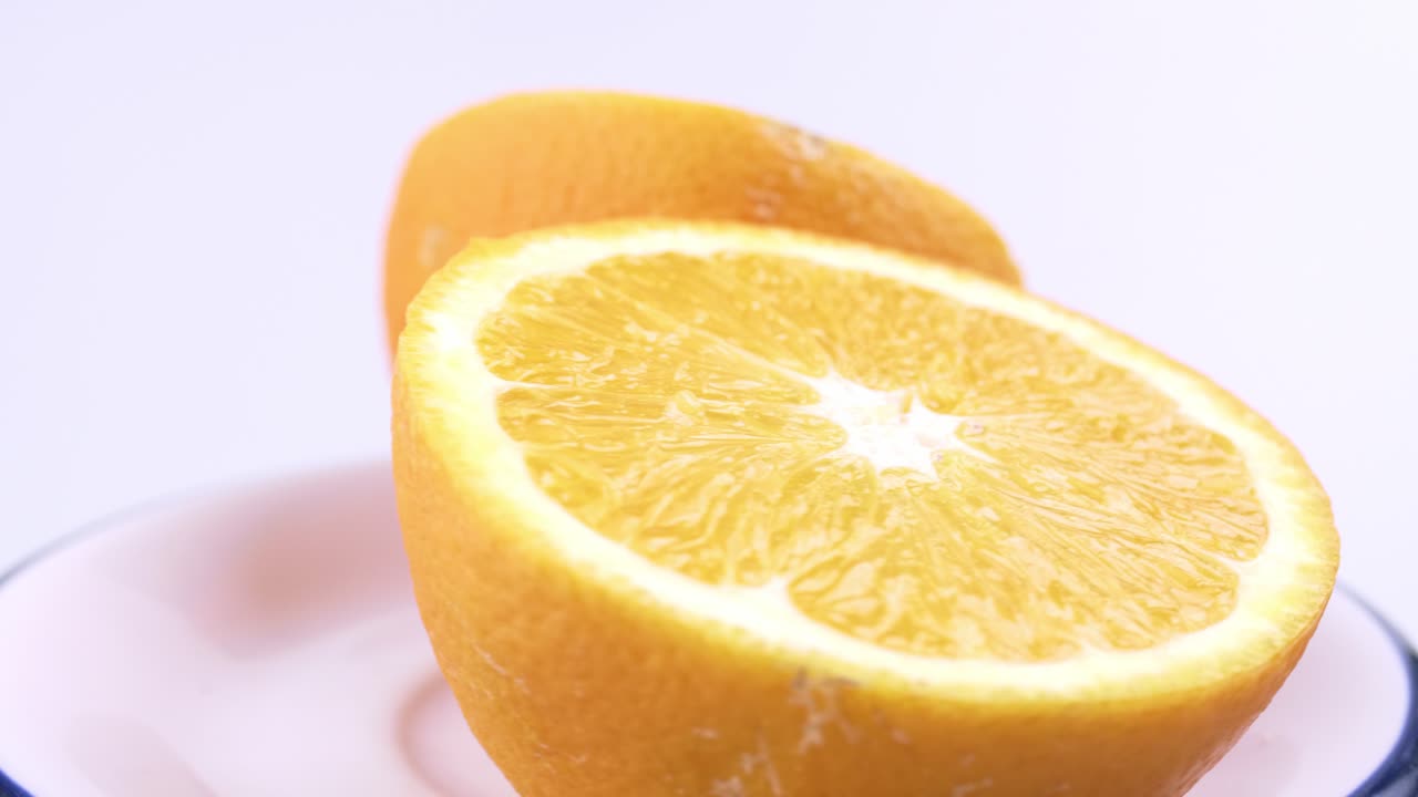 primer plano de naranja valencia fresca en rodajas con fondo blanco enfoque superficial y girando lentamente