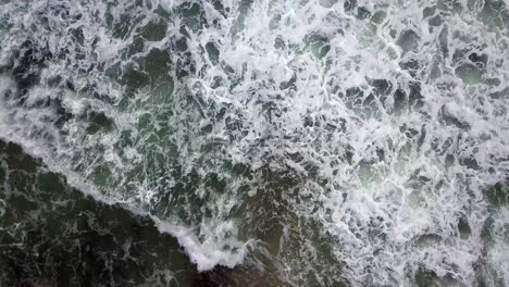 4K-Hovering-above-hypnotic-water-crashing-on-shoreline