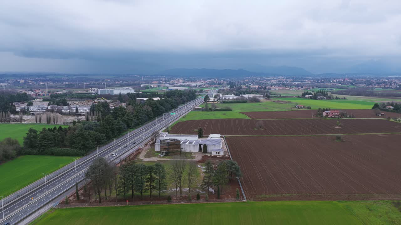 Aerial view of a highway crossing the countryside near Vimercate, Lombardy, Italy, on a cloudy day