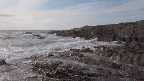 waves crashing against a rocky cove on a summer’s evening