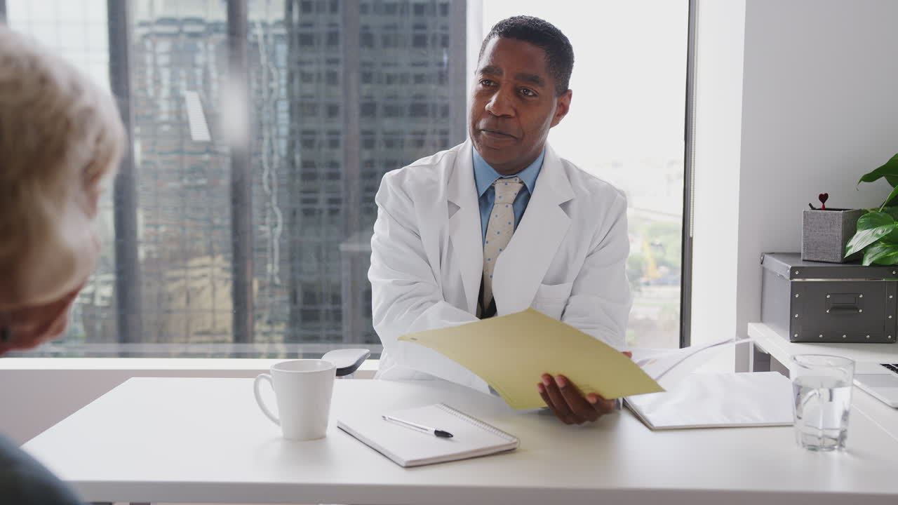 médico masculino con historial de paciente que se reúne con una pareja de ancianos en la oficina para consultar