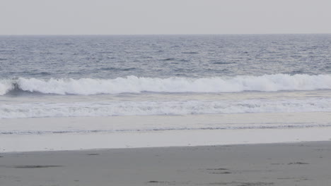 static shot of waves crashing on the shore of a beach in canas island