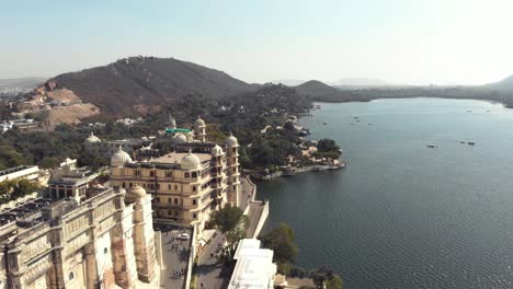 View-of-Taj-Fateh-Prakash-Palace-near-Lake-Pichola-in-Udaipur,-Rajasthan,-India---Aerial-Fly-over-shot