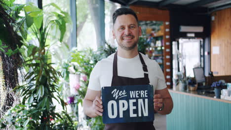 florist store owner holding open sign