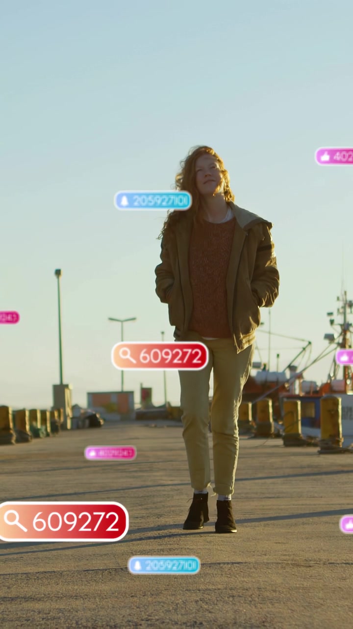 Vertical video: Woman walking pier nearing camera causing red 609272 badge pink blue counts for ads