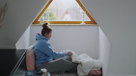 woman relaxing in a cozy window seat