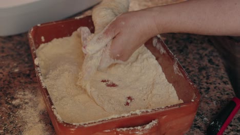 woman covers pig tripe with cornmeal during sausage ritual in minho north portugal