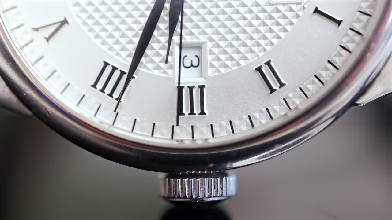 Close up of a silver watch on a blurred background