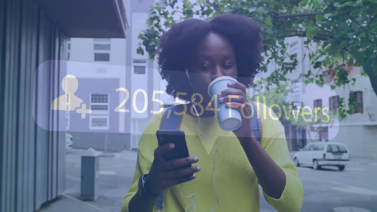 Animation of social media notification over african american woman using smartphone in city street