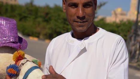 arab man stroking the muzzle of a camel