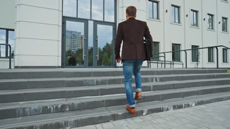 man walking down stairs outside office building