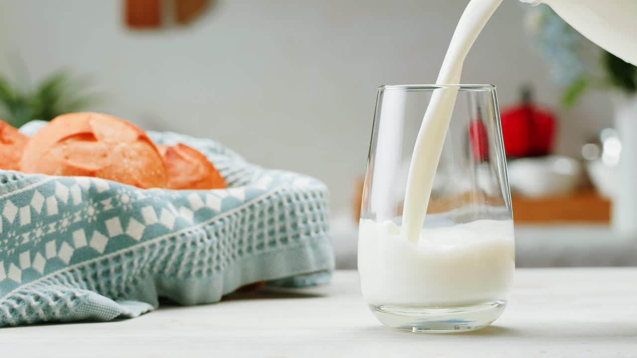 la leche se vierte en un vaso junto al pan