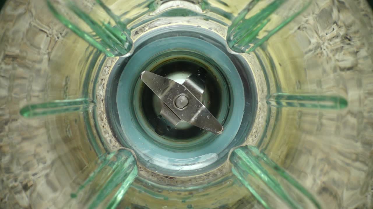 Falling of ice in a blender bowl. Slow motion. Preparation of smoothie in the blender. Top view