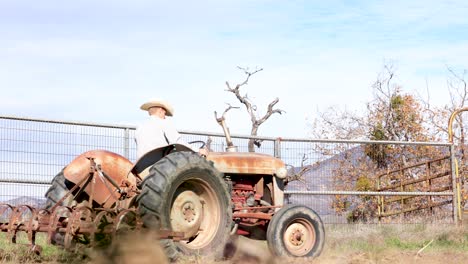 cowboy driving tractor in a round pen arena