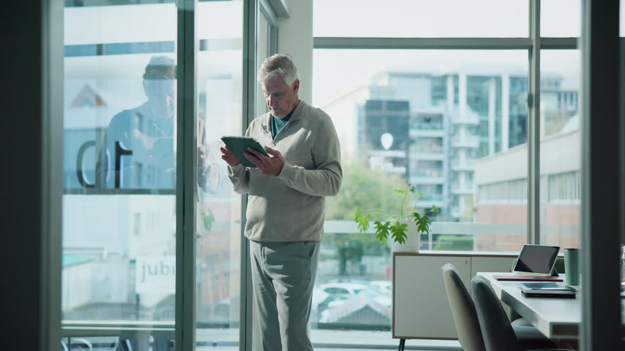 Senior Businessman Using Tablet in Modern Office