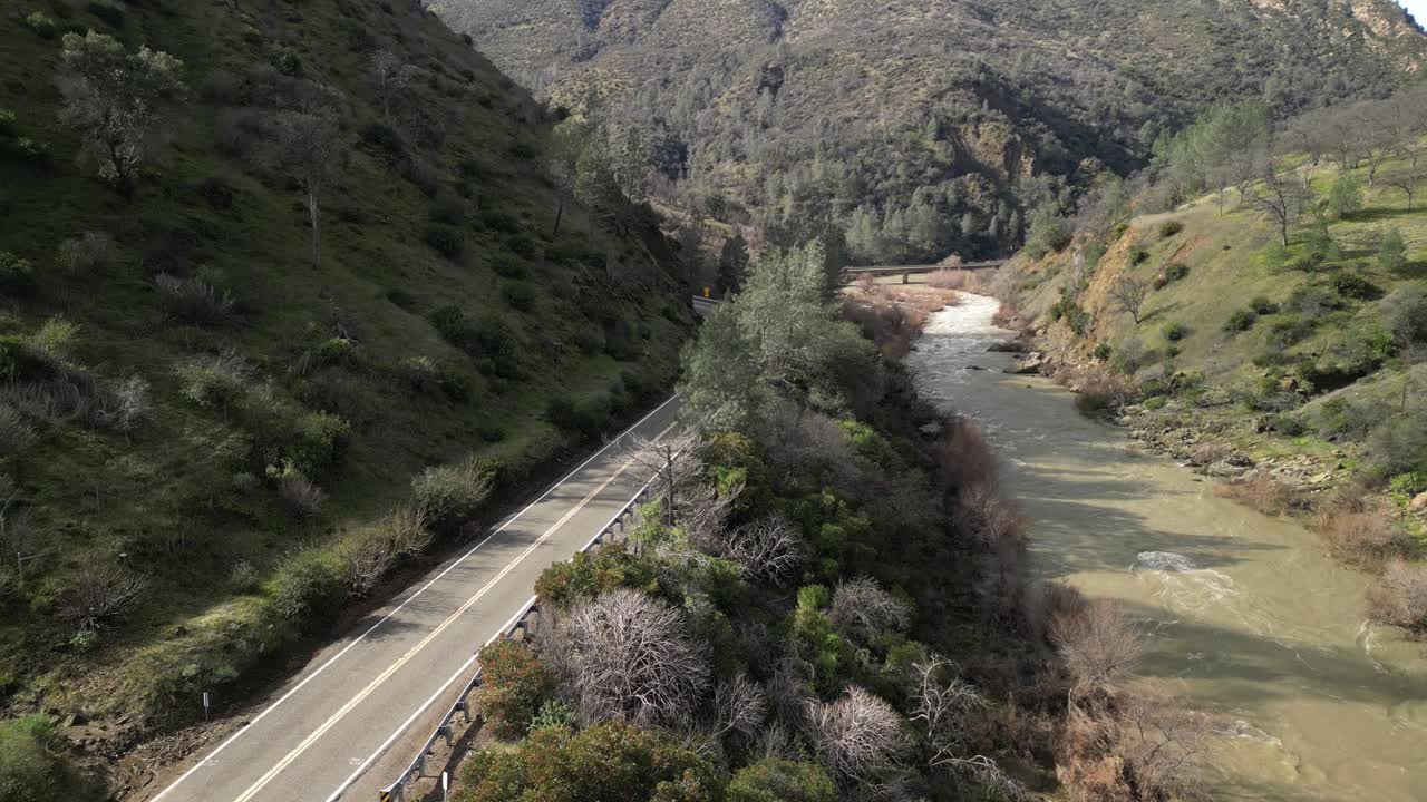 An expansive aerial perspective reveals the diverse terrain surrounding Cache Creek’s path through Rumsey. A lone car drives through the path of Cache Creek.