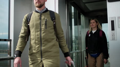 people entering and exiting an elevator at an airport