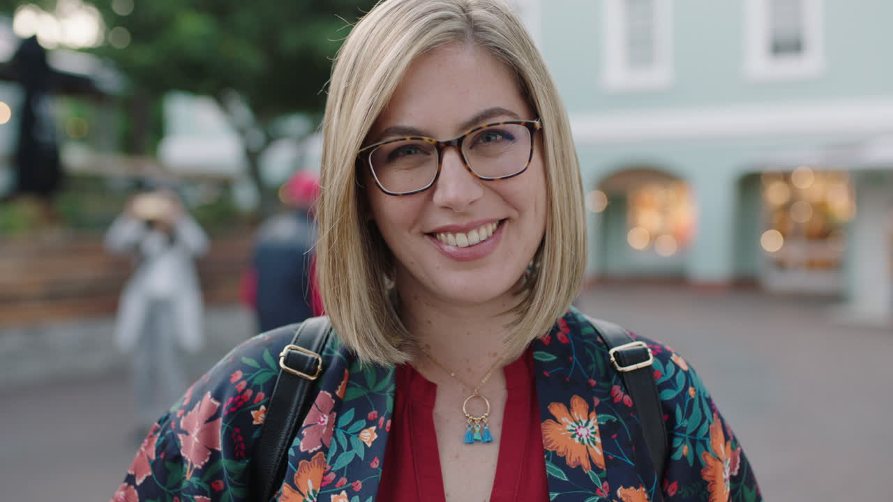 ritratto di una donna d'affari bionda alla moda che ride positivamente indossando occhiali camicia floreale che si diverte a viaggiare in città