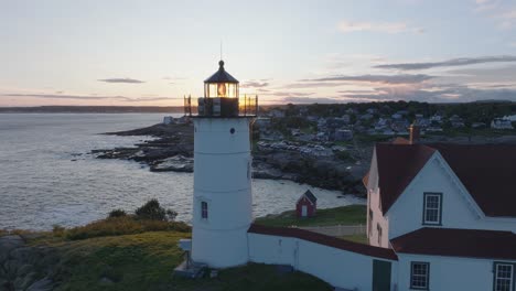 aerial drone shot of york beach maine flying over cape neddick nubble lighthouse into the sunset