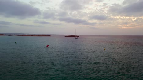 Velero-Al-Atardecer-Junto-A-La-Isla-En-Alta-Mar