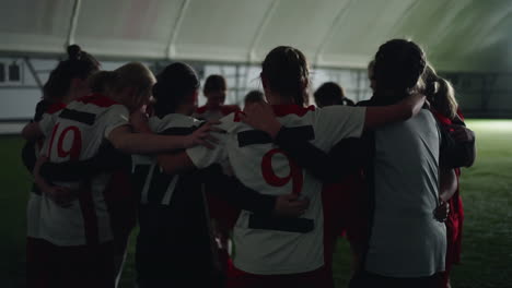 women's soccer team huddles together before a game