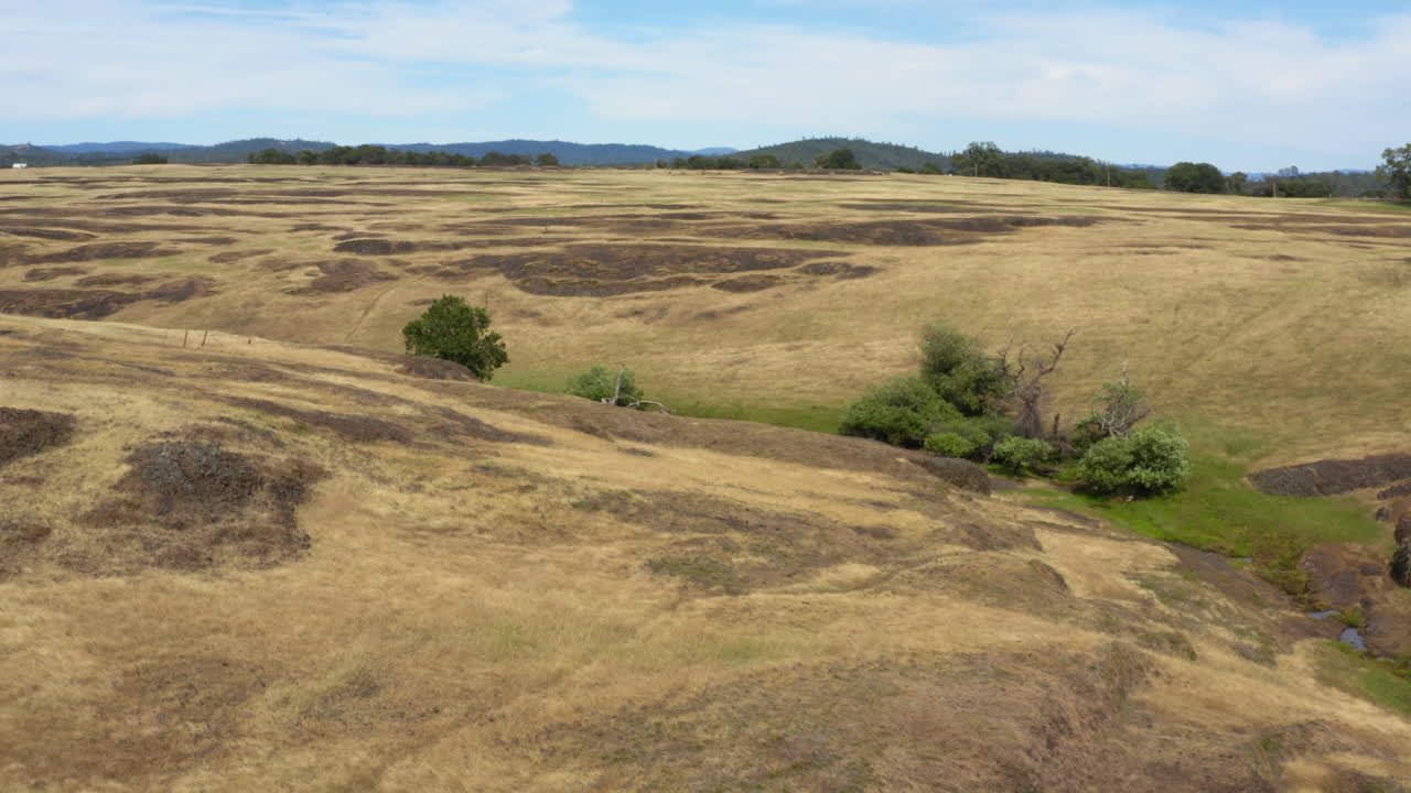 Backwards flying drone shot revealing large dry yellow grass prairie on top of Tabletop Mountain, nature in California
