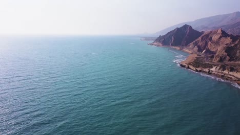 Dunstiger-Tag-Im-Meer,-Der-Berggipfel-In-Strandnähe,-Wunderschöne-Küstenlandschaft,-Sandstrand,-Grün-blaue-Farbe,-Meereswelle,-Erosionseffekt-Auf-Felslandschaft,-Skyline-Horizont-Im-Hintergrund