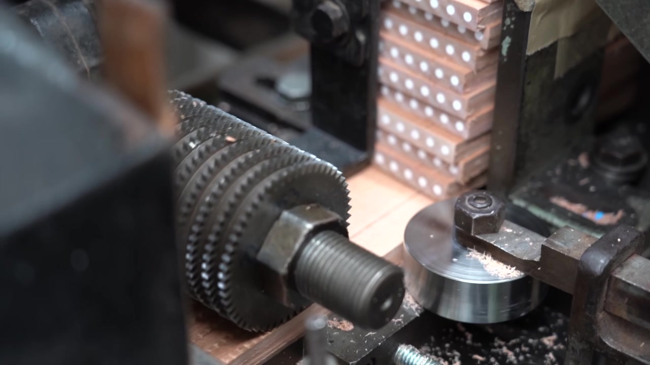 Mola circolare che modella fusti di matita impilati all'interno di una fabbrica di matite in legno.
