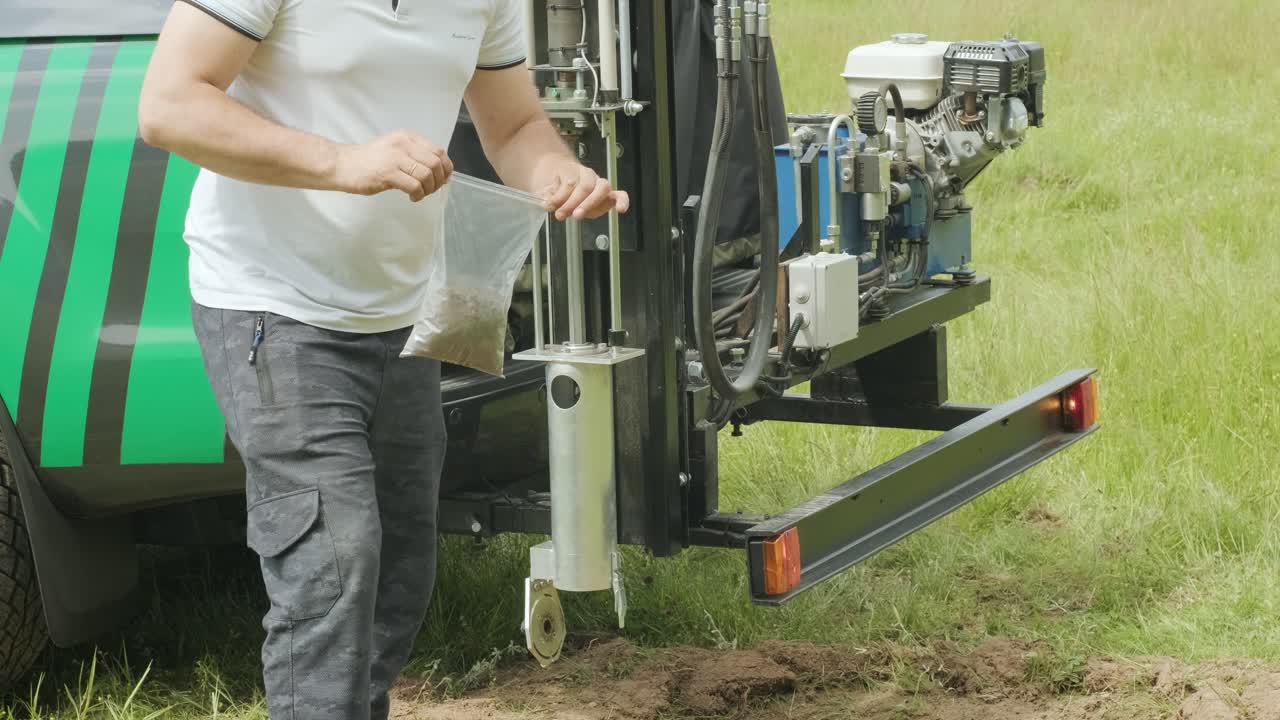 uomo che mette la terra nera in pacchetto. esame del suolo di agronomia. indagine geotecnica. raccolta della terra nera sul campo per l'esame e l'analisi. attrezzature speciali per il pickup
