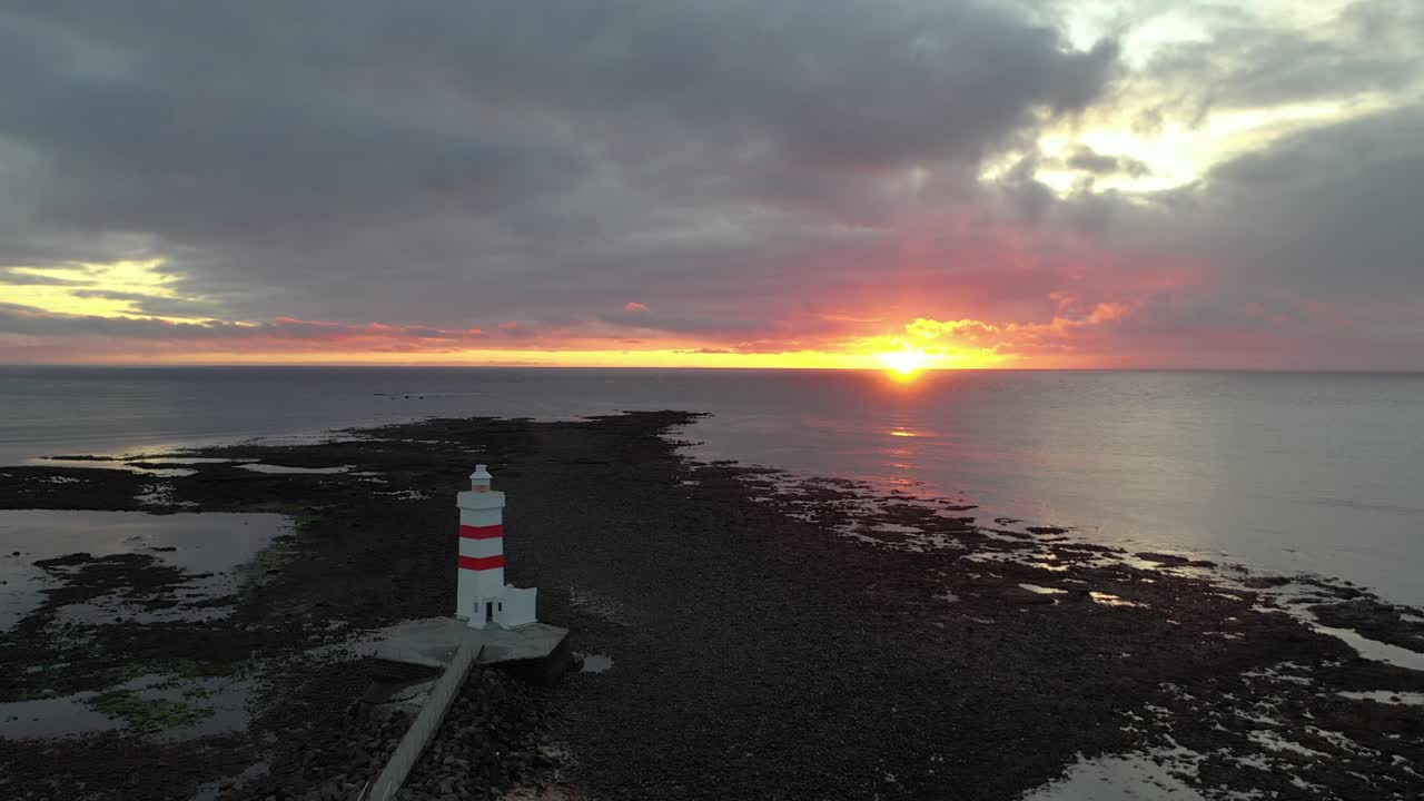 Sunset at Garðskagaviti lighthouse on rocky point of Iceland peninsula